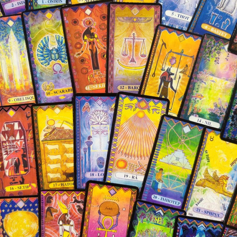 Cartes de l'Oracle Égyptien étalées en éventail, illustrant la richesse des symboles égyptiens.